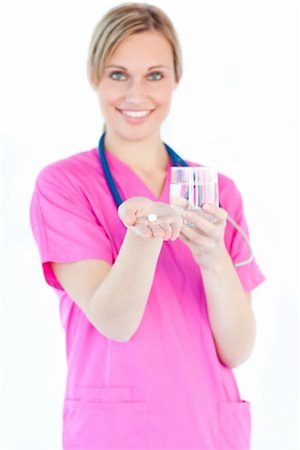 doctor business computer - Bright female nurse holding pills and a glass water smiling at the camera against white background Stock Photo - Budget Royalty-Free & Subscription, Code: 400-05243618