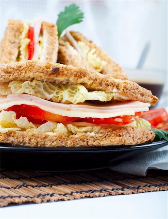 fresh and delicious classic club sandwich over a black glass dish with coffee and vegetable Stock Photo - Budget Royalty-Free & Subscription, Code: 400-05254231