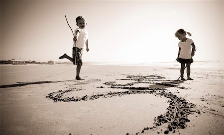 family on sand drawing - Lovely young brother and sister write words in the sand together Photographie de stock - Aubaine LD & Abonnement, Code: 400-05254632