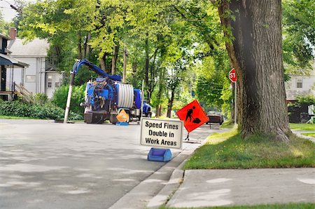 sewer - sanitation sewer maintenance truck in service with traffic warning road signs with trees along a community avenue Stock Photo - Budget Royalty-Free & Subscription, Code: 400-05254653