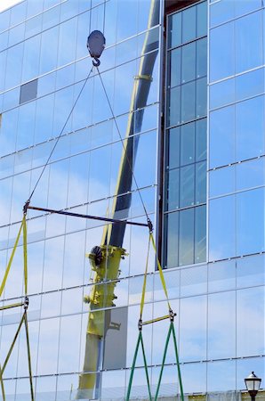 reflection  geometric lines and shapes of  work in progress of glass highrise building and crane industrial machinery Fotografie stock - Microstock e Abbonamento, Codice: 400-05254694