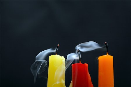 simsearch:693-06018760,k - Three colored extinguished  candles with smoke on black background Photographie de stock - Aubaine LD & Abonnement, Code: 400-05255624