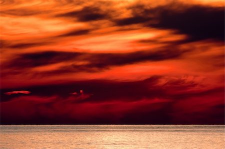 A sunset over a lake. The colors in the sky and on the clouds are fiery red and orange. Stock Photo - Budget Royalty-Free & Subscription, Code: 400-05256124