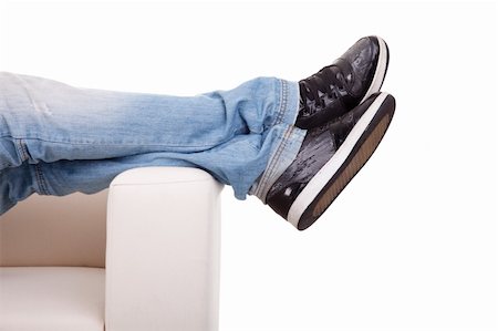 Detail, of some legs stretched on the couch, isolated on white, studio shot Stock Photo - Budget Royalty-Free & Subscription, Code: 400-05257890