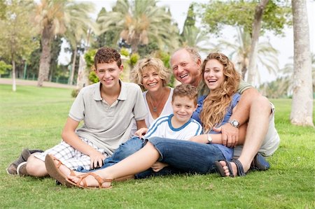 simsearch:400-04216385,k - front view of happy family sitting in park and posing for camera Foto de stock - Super Valor sin royalties y Suscripción, Código: 400-05258263