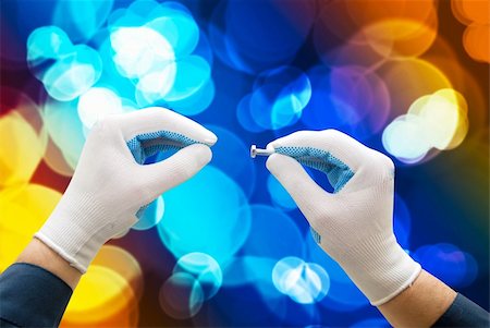 simsearch:400-05695467,k - Two hand in gloves with screw on defocused light colors background Fotografie stock - Microstock e Abbonamento, Codice: 400-05258939