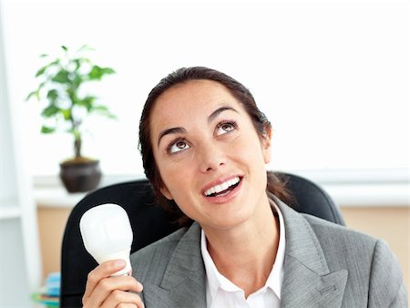 pic of electric shocked - Surprised businesswoman holding a light bulb sitting in her office at her desk Stock Photo - Budget Royalty-Free & Subscription, Code: 400-05259170