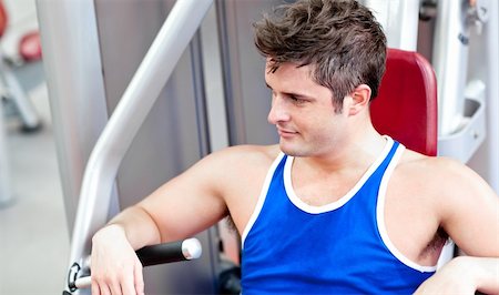 simsearch:400-05677914,k - Relaxed young man using a bench press in a fitness center Stock Photo - Budget Royalty-Free & Subscription, Code: 400-05259224