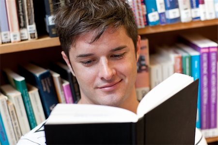 simsearch:400-04295114,k - Portrait of a smiling male student reading a book sitting on the floor in a bookshop Photographie de stock - Aubaine LD & Abonnement, Code: 400-05259232