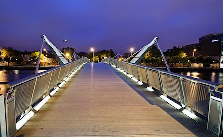 Illuminated pedestrian bridge across river Liffey in Dublin photographed in twilight Stock Photo - Budget Royalty-Free & Subscription, Code: 400-05259425