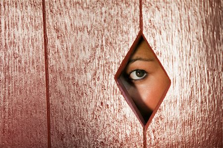 edbockstock (artist) - Woman peeks through a diamond shaped hole in a wall. Horizontal shot. Photographie de stock - Aubaine LD & Abonnement, Code: 400-05250526