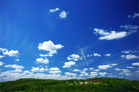 roxxer (artist) - Image of a blue sky with the clouds on a sunny day and some rural houses in the green forest. Fotografie stock - Microstock e Abbonamento, Codice: 400-05251607