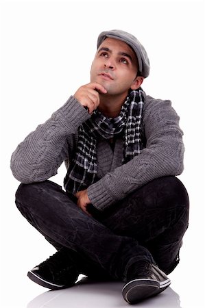 Portrait of a young man sitting on the floor, thinking and looking up, in autumn/winter clothes, isolated on white, Studio shot Stock Photo - Budget Royalty-Free & Subscription, Code: 400-05253834