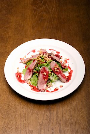 simsearch:400-07036577,k - Meat with salad and nuts  served on the white round  plate Stock Photo - Budget Royalty-Free & Subscription, Code: 400-05265050