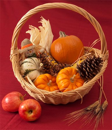 simsearch:400-05265311,k - A Thanksgiving basket of miniature pumpkins, Indian corn, scarecrow doll and cone against a red background, with two apples in front. Foto de stock - Super Valor sin royalties y Suscripción, Código: 400-05265310