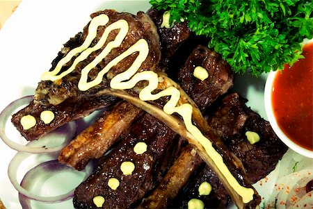simsearch:400-05266390,k - Fried ribs served with vegetables and sauce Foto de stock - Royalty-Free Super Valor e Assinatura, Número: 400-05266267