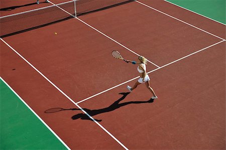 simsearch:400-06061549,k - young fit woman play tennis outdoor on orange tennis field at early morning Photographie de stock - Aubaine LD & Abonnement, Code: 400-05266472
