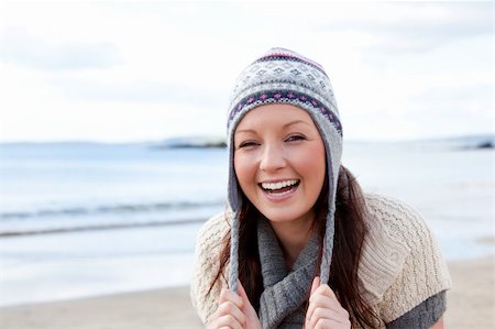 Joyful woman wearing hat and scarf on the beach in front of the ocean Stock Photo - Budget Royalty-Free & Subscription, Code: 400-05266722