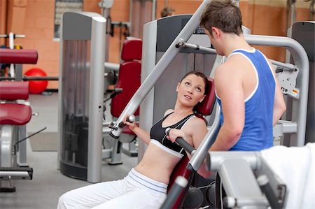 simsearch:400-05677914,k - Sporty woman  sitting on a shoulder press talking with her coach in a fitness centre Stock Photo - Budget Royalty-Free & Subscription, Code: 400-05266981