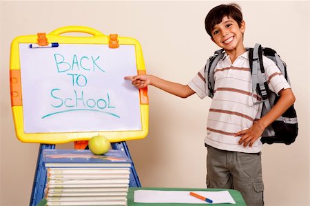 Smiling school boy pointing at white board on his classroom Stock Photo - Budget Royalty-Free & Subscription, Code: 400-05260010