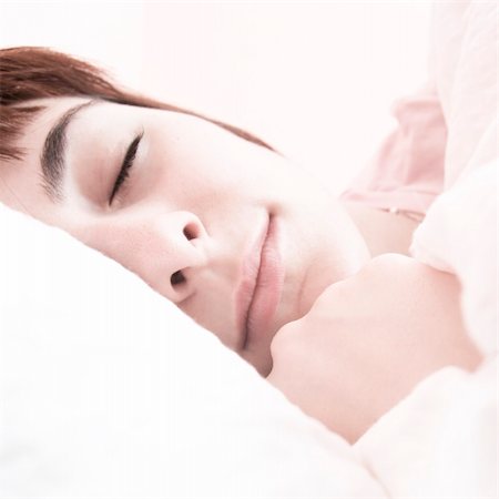 Beautiful young woman sleeping on bed in her bedroom at home in the morning. Fotografie stock - Microstock e Abbonamento, Codice: 400-05261183