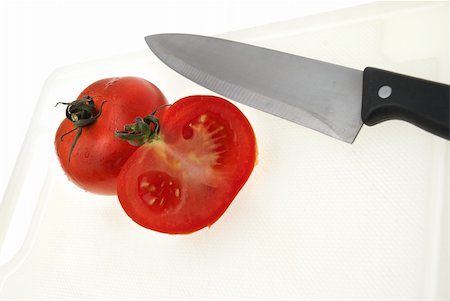 Cutting white plastic board with a knife and tomato isolated on a white background. Foto de stock - Super Valor sin royalties y Suscripción, Código: 400-05263654