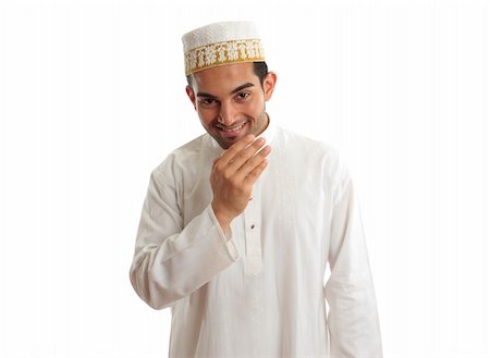 Smiling friendly ethnic man wearing a traditional embroidered robe with ruby buttons and a white and gold embroidered topi hat.  White background. Photographie de stock - Aubaine LD & Abonnement, Code: 400-05274528