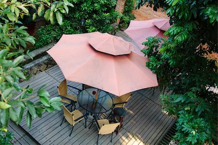 simsearch:851-02960697,k - Summer Patio with tables and wooden chairs under umbrella in garden Stock Photo - Budget Royalty-Free & Subscription, Code: 400-05276159