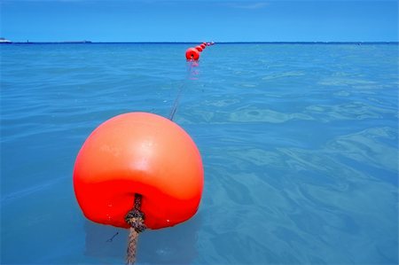 floating object on water - red buoy row floating blue sea with rope closeup perspective Stock Photo - Budget Royalty-Free & Subscription, Code: 400-05279664