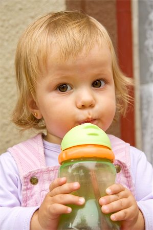 fastof (artist) - little girl drinks from a small bottle and with interest looks aside Stock Photo - Budget Royalty-Free & Subscription, Code: 400-05271194