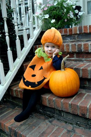 Cute little girl, wearing a pumpkin costume, leans impatiently on a pumpkin.  She is waiting for Halloween to arrive. Photographie de stock - Aubaine LD & Abonnement, Code: 400-05271733