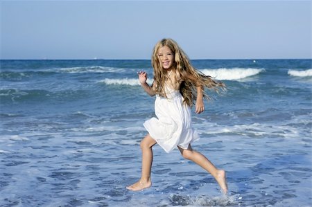 Little girl running beach shore splashing water in blue sea Foto de stock - Royalty-Free Super Valor e Assinatura, Número: 400-05273743