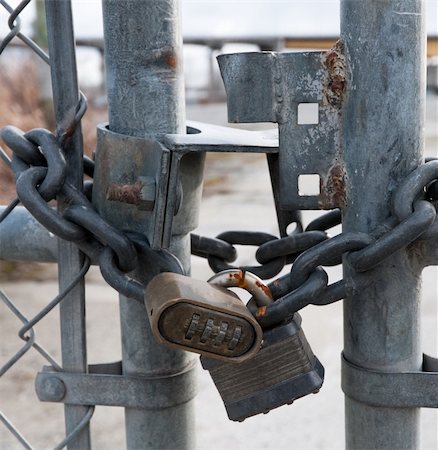 Two pad locks on a chained gate. The lock is being cut through over time to gain entrance to the yard. Stock Photo - Budget Royalty-Free & Subscription, Code: 400-05284296