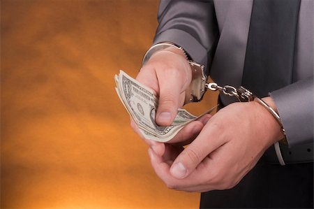 stretching a dollar - Arrest, close-up man's hands with money in handcuffs. Stock Photo - Budget Royalty-Free & Subscription, Code: 400-05285156