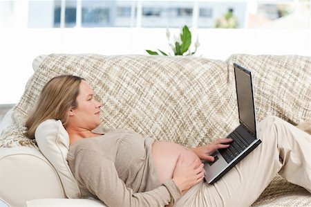 simsearch:400-04767824,k - Caucasian pregnant woman working on a laptop while relaxing on the sofa Foto de stock - Royalty-Free Super Valor e Assinatura, Número: 400-05285295