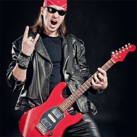 Rock-star perfoming loud music on red electric guitar Stock Photo - Budget Royalty-Free & Subscription, Code: 400-05286147