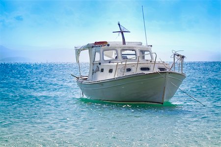 White boat anchored in a clean blue water. Foto de stock - Royalty-Free Super Valor e Assinatura, Número: 400-05287379