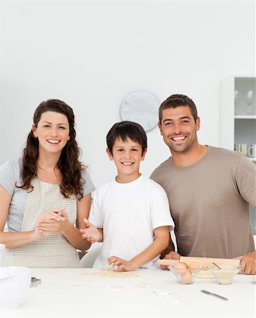 Cute boy with his parents in his kitchen while preparing cookies Stock Photo - Budget Royalty-Free & Subscription, Code: 400-05287511