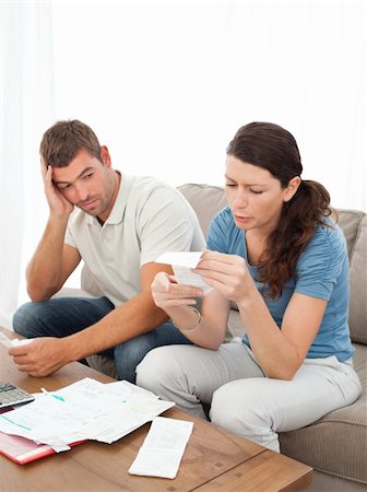 simsearch:400-05746763,k - Stressed couple doing their accounts sitting on the sofa at home Stock Photo - Budget Royalty-Free & Subscription, Code: 400-05287527