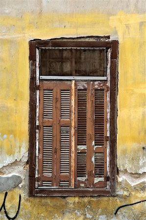 simsearch:400-05352419,k - Boarded up window shutters and grungy yellow wall. Abandoned house detail. Photographie de stock - Aubaine LD & Abonnement, Code: 400-05287917