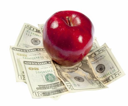A red apple sits on top of a pile of $20 bills to illustrate the cost of education, food, or health care.  Studio shot on a white background. Stock Photo - Budget Royalty-Free & Subscription, Code: 400-05280570