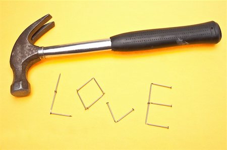 Word Love in Nails Symbolizing the Idea that Love Takes Work.  On a Vibrant Yellow Background. Stock Photo - Budget Royalty-Free & Subscription, Code: 400-05280857