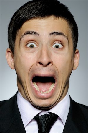 Portrait of stressed  business man in formal suit and black tie screaming.  gray background Stock Photo - Budget Royalty-Free & Subscription, Code: 400-05281713