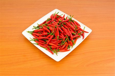 simsearch:400-04288181,k - Hot peppers in the plate on wooden table Photographie de stock - Aubaine LD & Abonnement, Code: 400-05297449
