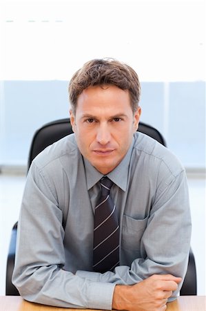 simsearch:400-04287211,k - Serious manager sitting at a table in an office Stock Photo - Budget Royalty-Free & Subscription, Code: 400-05298015