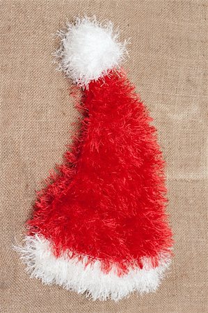 simsearch:400-08409193,k - Red cristmas hat santa put on sackcloth Fotografie stock - Microstock e Abbonamento, Codice: 400-05298076