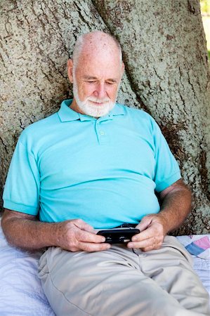 Senior man texting on his smart phone. Stock Photo - Budget Royalty-Free & Subscription, Code: 400-05298118