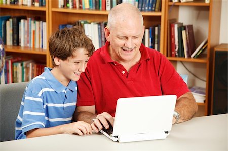 person reading a book confused - Father and son using the computer in the library. Photographie de stock - Aubaine LD & Abonnement, Code: 400-05298112