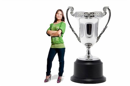 simsearch:832-03640688,k - A beautiful hispaniv woman standing beside a silver championship cup, sports trophy award. Foto de stock - Royalty-Free Super Valor e Assinatura, Número: 400-05299100