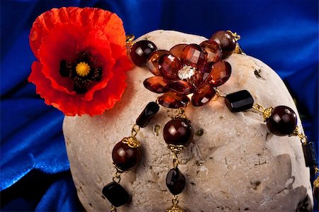 simsearch:630-01492287,k - Necklace, flower and stone on a blue textile Foto de stock - Royalty-Free Super Valor e Assinatura, Número: 400-05299222